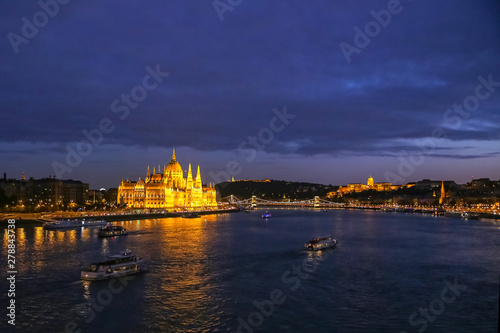 Brightly lit palace of the Hungarian Parliament and the bridges on the Danube at night
