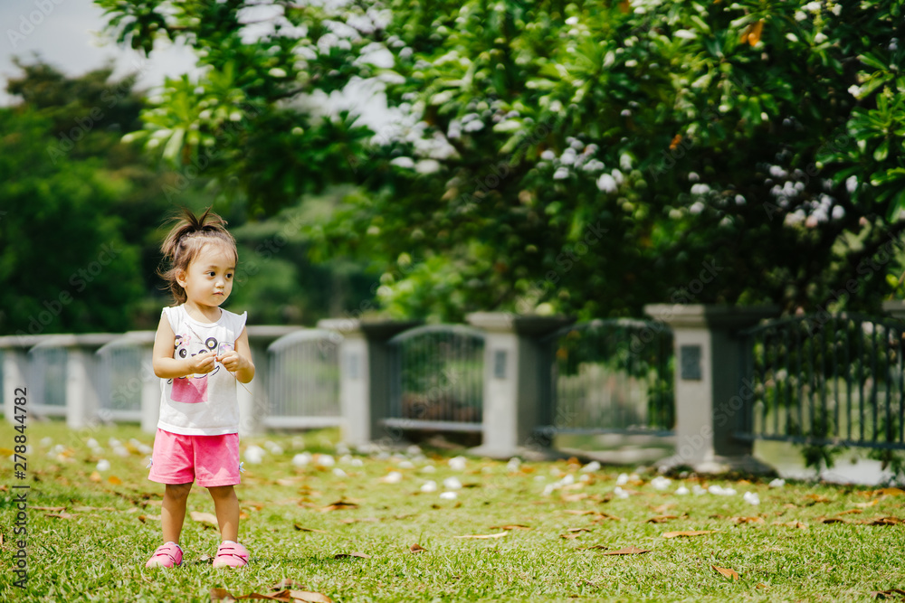 Asian toddler girl running in the park at the spring or summer day. Asian toddler girl running in the park at the spring or summer day.