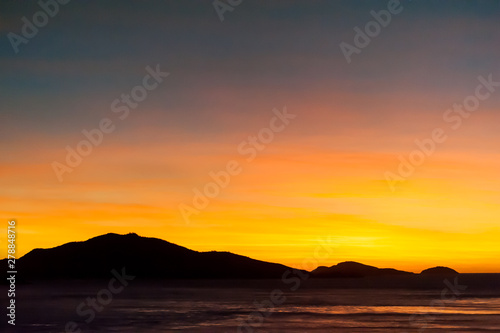Hills silhouetted in beautiful orange and yellow sunrise