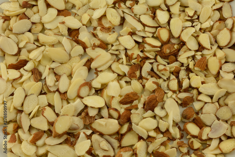 Background of heap of raw sliced almond nuts on white Background of heap of raw sliced almond nuts on white