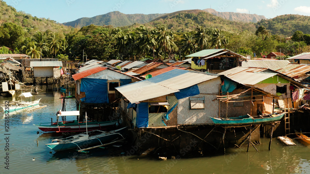 Coron city with slums and poor district. Old wooden house standing on the sea in the fishing village. Houses of local poor people.Busuanga, Coron, Philippines. houses community standing in water in Coron city with slums and poor district. Old wooden house standing on the sea in the fishing village. Houses of local poor people.Busuanga, Coron, Philippines. houses community standing in water in