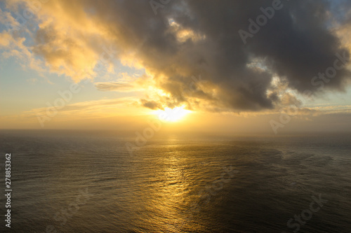 Sunset over the horizon with clouds. Light reflecting off the water. New Zealand. © michaeldasso