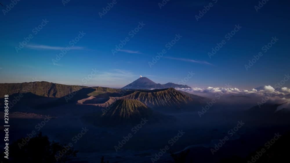 Sunset over the Iconin Mount Bromo, Indonesia, with rolling clouds and puffs coming from the rear volcano. Sunset over the Iconin Mount Bromo, Indonesia, with rolling clouds and puffs coming from the rear volcano.