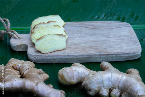 Fresh ginger on wooden chopping board, herb ingredient concept