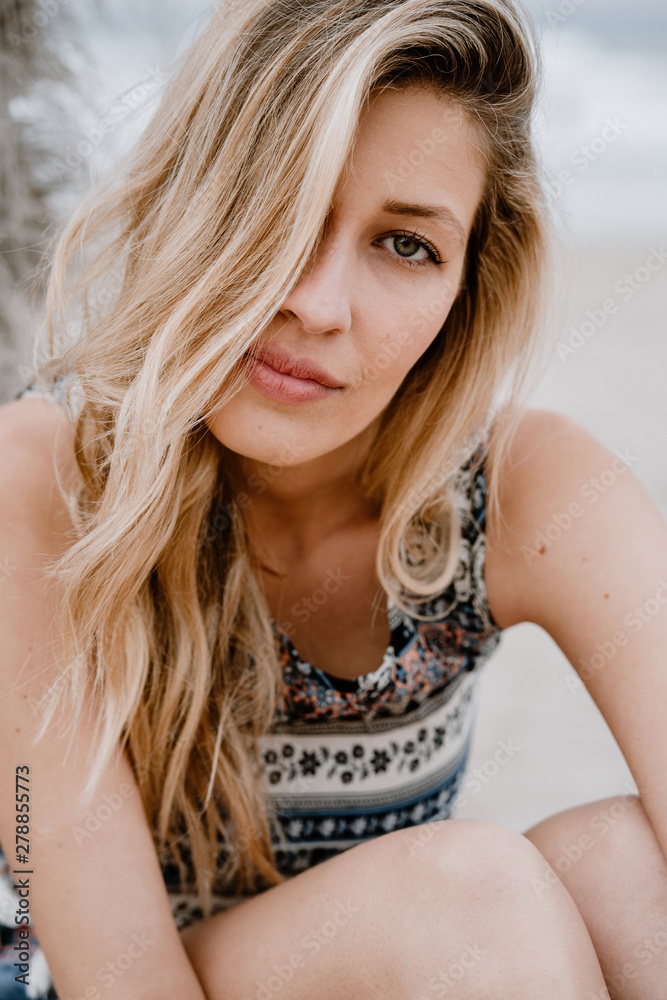 Close-up portrait of young beautiful blonde seductive woman looking at camera