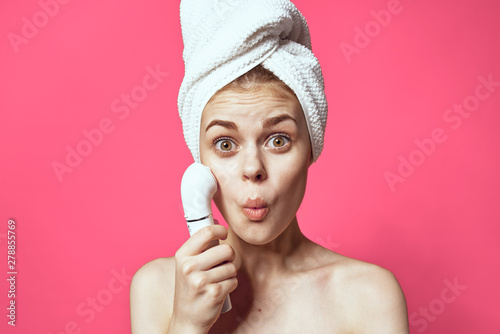 young woman applying moisturizer cream on her face