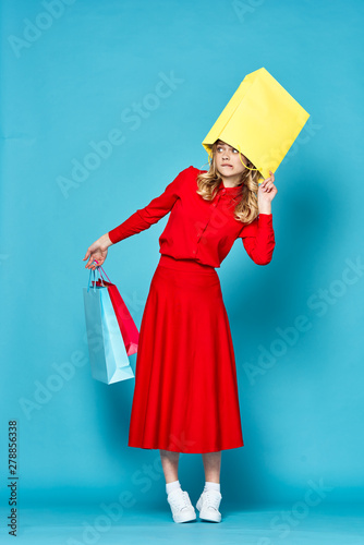 young woman in red dress with shopping bags