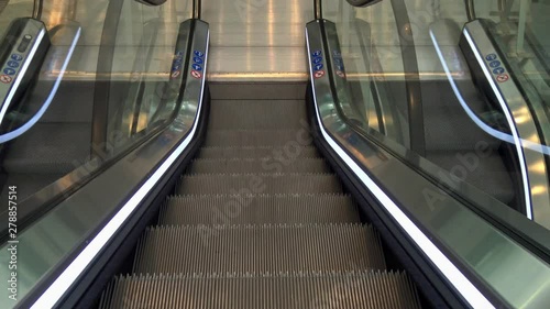 An escalator going down and arriving at the bottom. photo