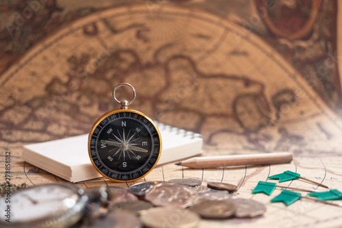 Compass on old vintage brown map background, journey planning concept