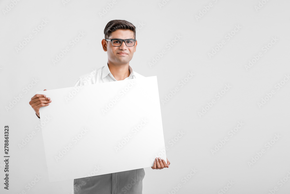 Young Indian business executive showing blank sign board over white background