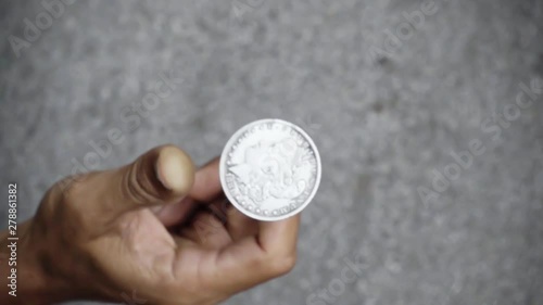 slowmotion shot tossing coin to flip on heads or tails