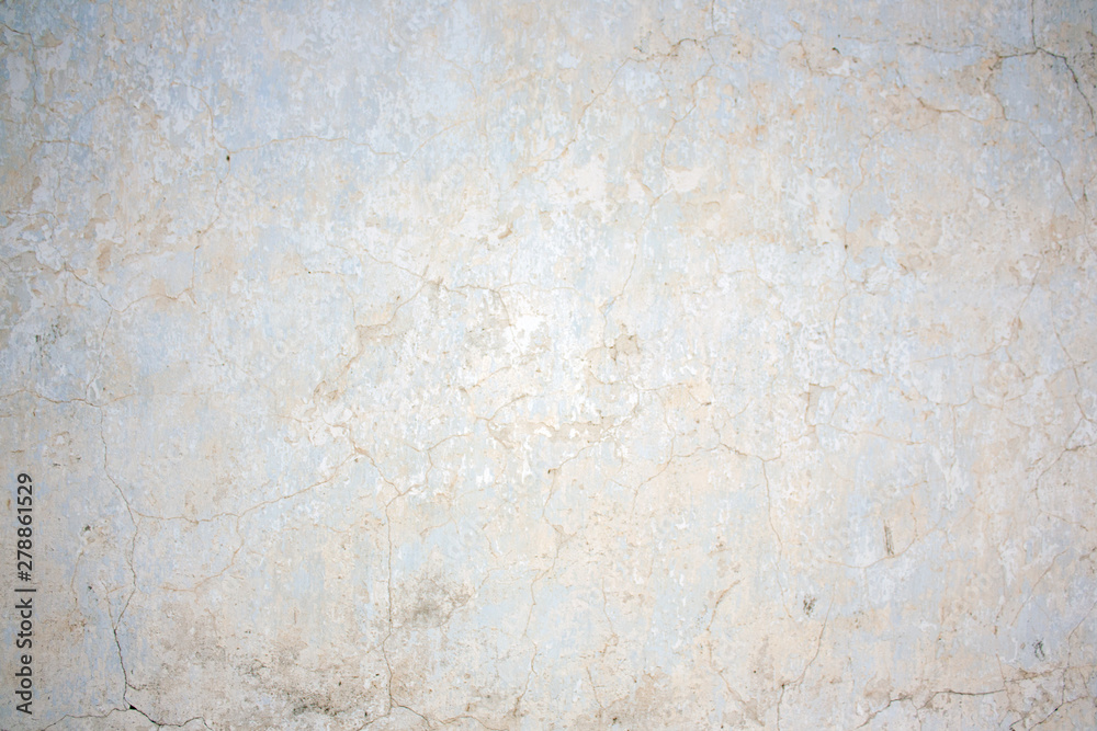 The natural texture of the stucco white wall of the house. Real cracks and damage from time and weather conditions.