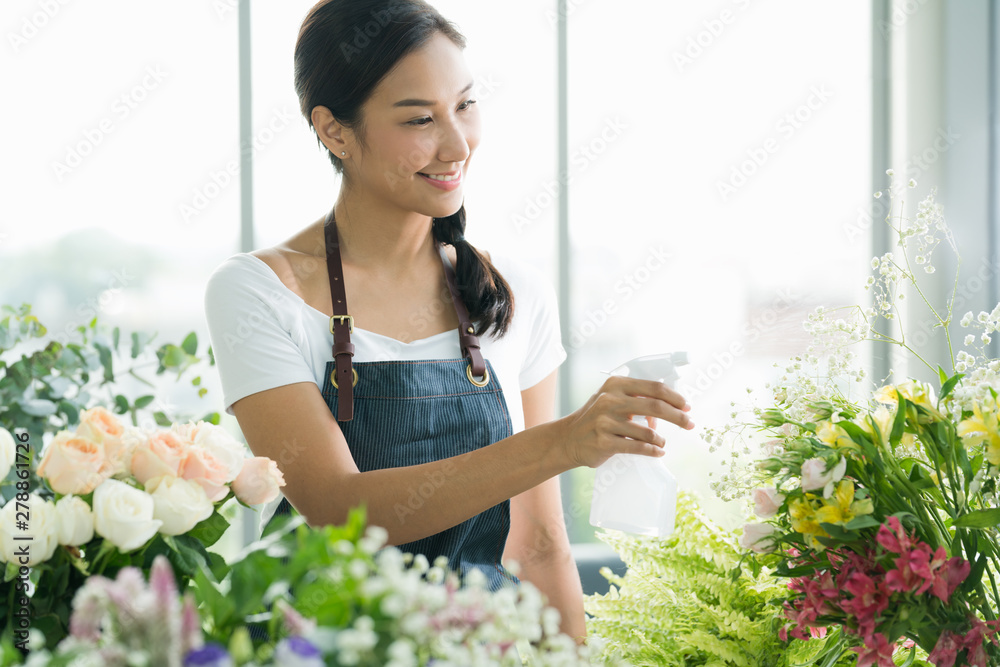 Young Asian woman entrepreneur/shop owner/ florist of a small flower shop business Young Asian woman entrepreneur/shop owner/ florist of a small flower shop business