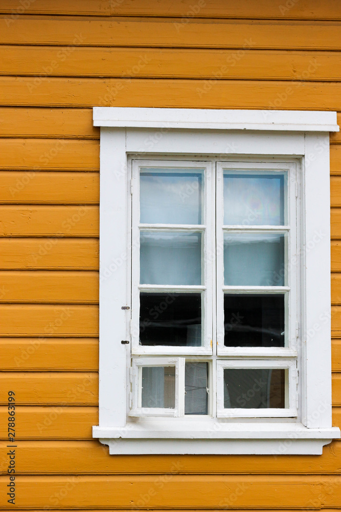 old white wooden window with shutters on the yellow wall old white wooden window with shutters on the yellow wall