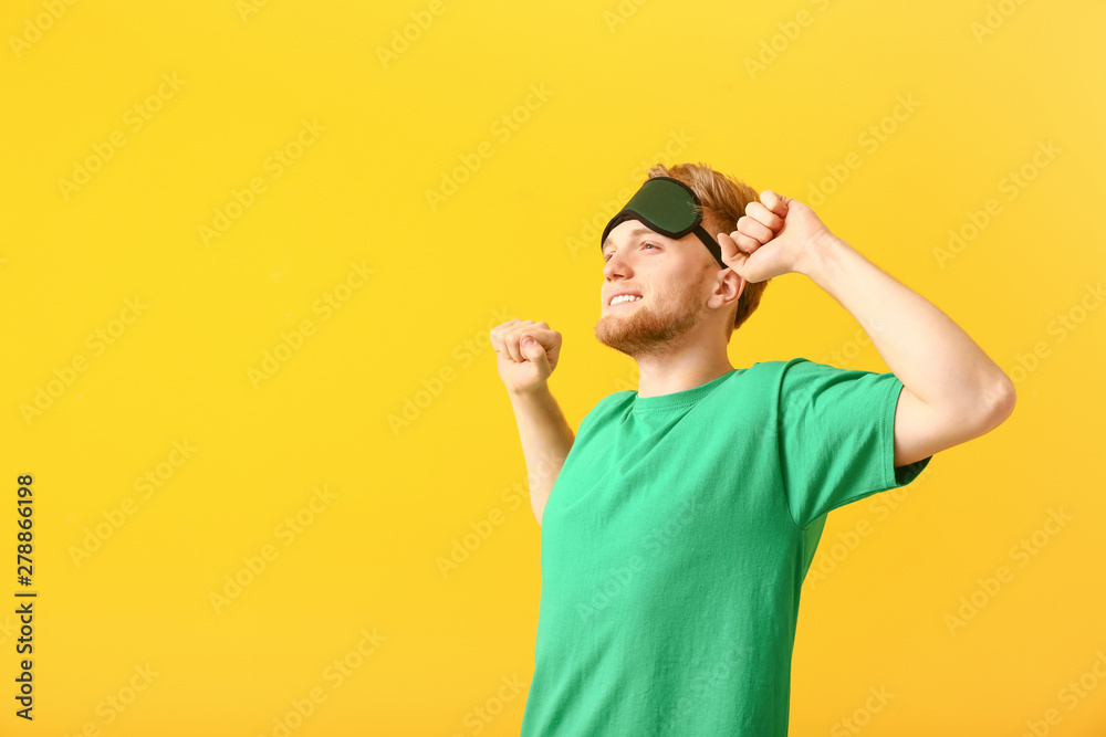 Naklejka premium Sleepy man with mask on color background