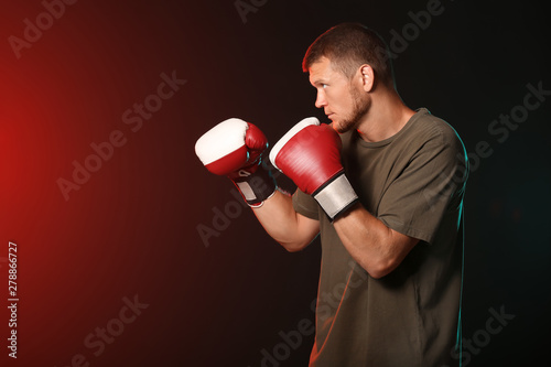 Strong male boxer on dark b...
