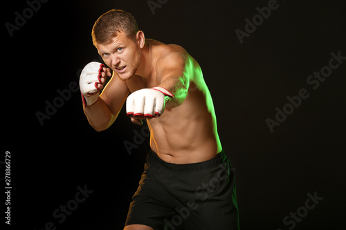 Strong male boxer on dark b...