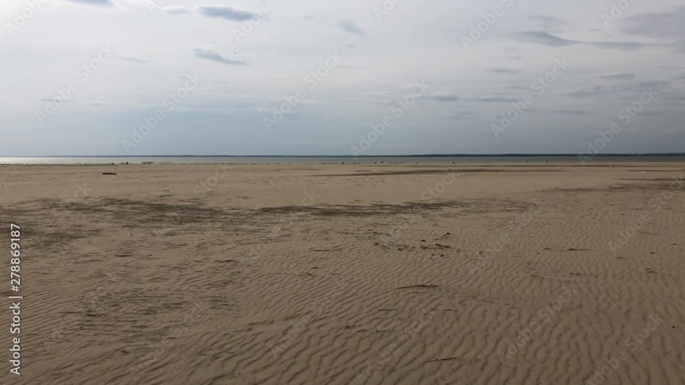 Empty beach in Siberia in the spring on a sunny day. A huge expanse of sand. Forward movement Empty beach in Siberia in the spring on a sunny day. A huge expanse of sand. Forward movement