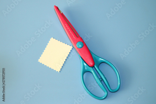 curly scrapbooking scissors for paper cutting and pastel cardboard cut in the shape of a rectangle