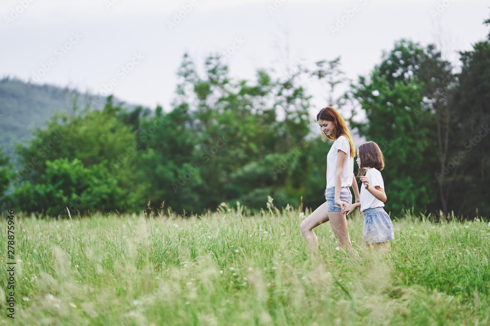 Fototapeta premium Mom and daughter walk in nature