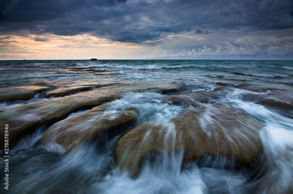 Dramatic rocks and waves on a gloomy weather at a beach in Kudat, Sabah, East Malaysia