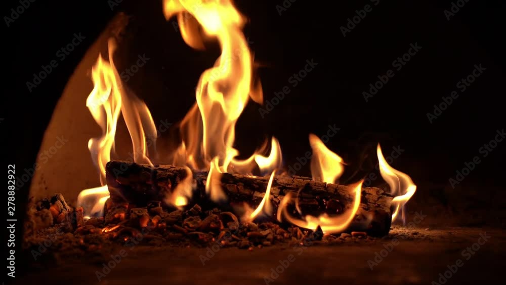 Fireplace burning. Close-up warm cozy burning fire in brick fireplace. Cozy backdrop. Dance of fire on black background Fireplace burning. Close-up warm cozy burning fire in brick fireplace. Cozy backdrop. Dance of fire on black background