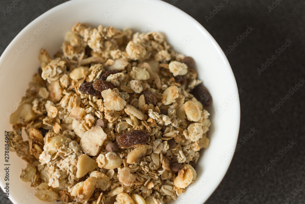 Oat flakes or Granola with nuts, dry fruit and berries on black stone table. Oat flakes as a healthy eating. Top view with copy space. Oat flakes or Granola with nuts, dry fruit and berries on black stone table. Oat flakes as a healthy eating. Top view with copy space.
