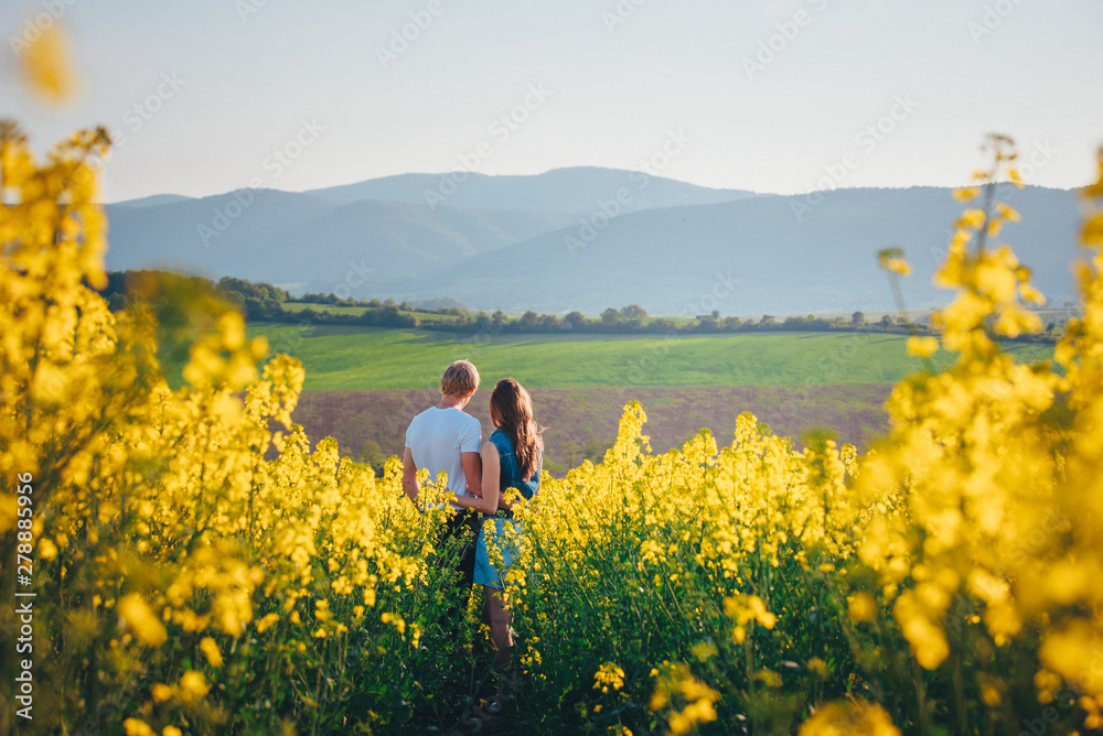 Beautiful young couple in spring colza field