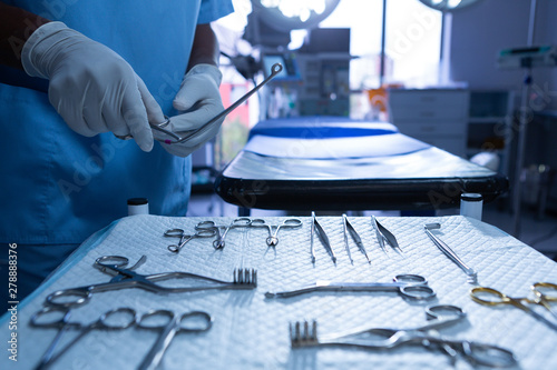 Surgeon holding surgical instrument in operating room of hospital