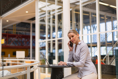 Businesswoman talking on mobile phone in the corridor at office