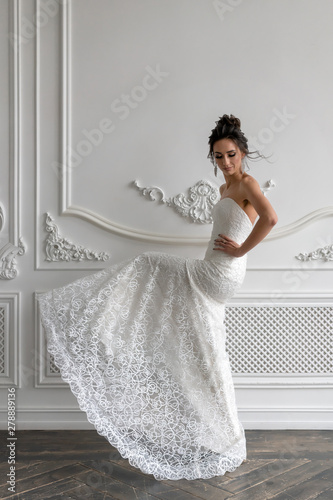 bride brunette in wedding dress silhouette. Elegant wedding look for a young girl.