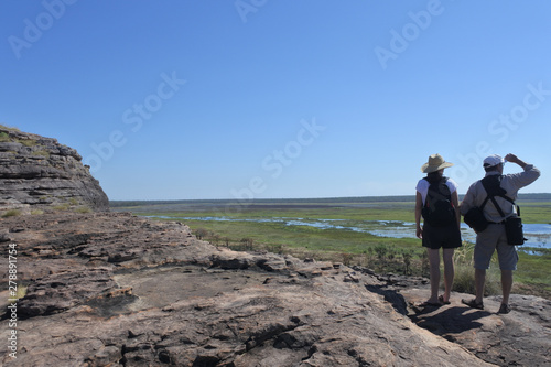 Tourist couple hiking at Ubirr rock art site in Kakadu National Park Northern Territory of Australia