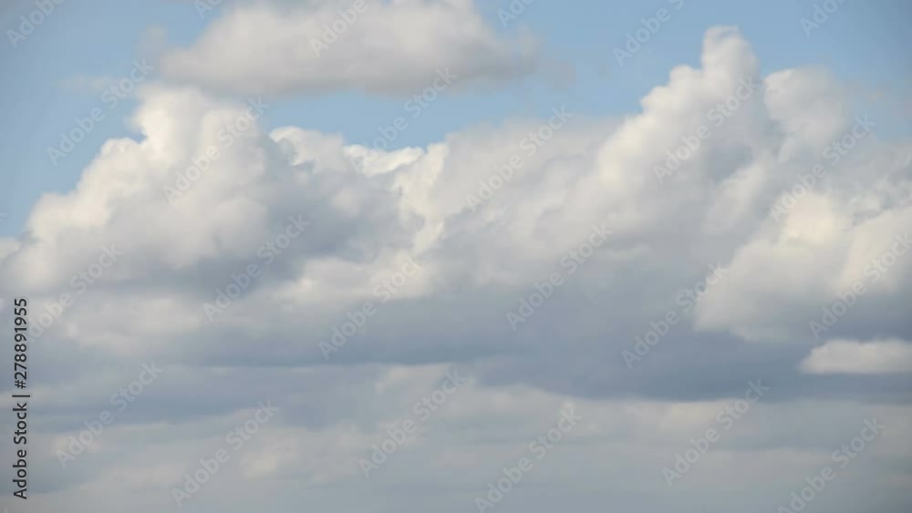 Time interval. Clouds are floating against the blue sky. The wind drives clouds across the sky