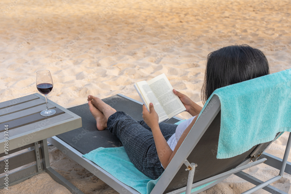 Female traveller reading books on the beach