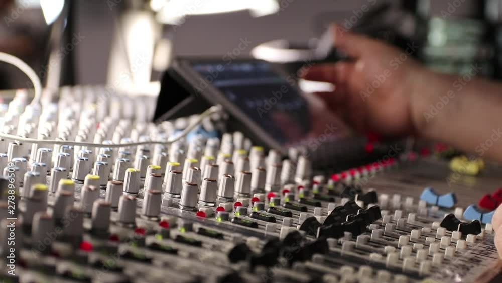 Sound engineer behind the sound mixing console controls the sound. Digital and analog sound mixer. Sound setting Sound engineer behind the sound mixing console controls the sound. Digital and analog sound mixer. Sound setting