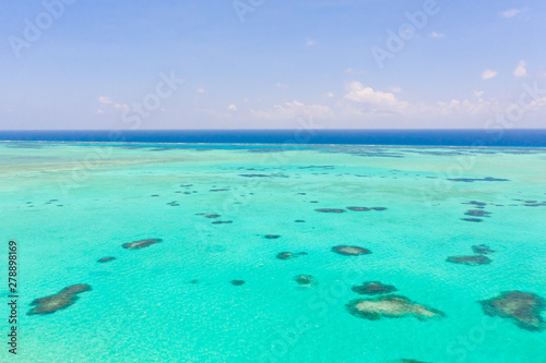 Sea water with lagoon and reefs, water background. Seascape with clear water. Large atoll with lagoon.