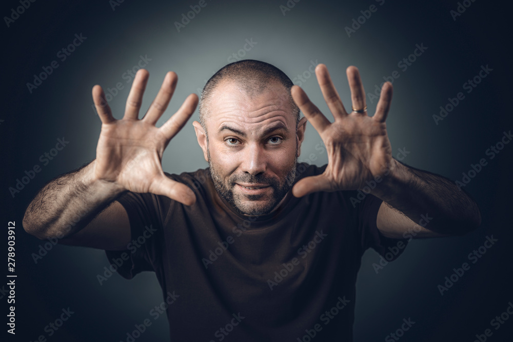 man in a shirt with open hand position as if he were performing magic.