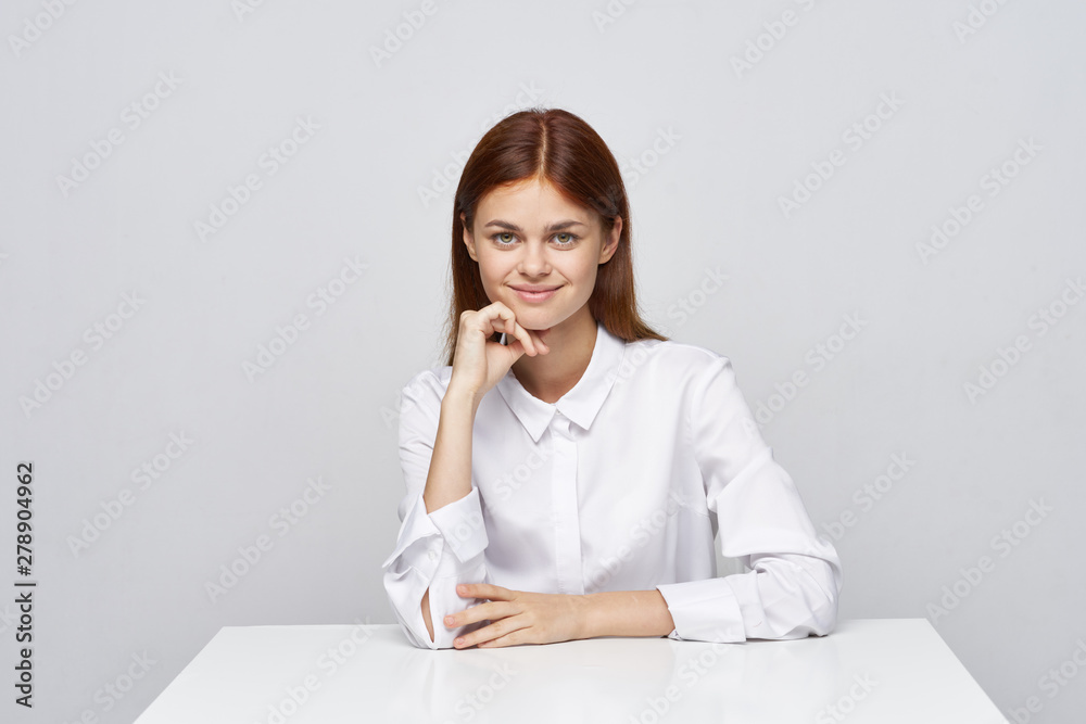 portrait of a young woman sitting at her desk portrait of a young woman sitting at her desk