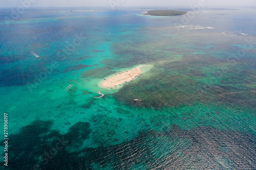 Naked Island, Siargao. The island of white sand on the atoll. Tourists relax on the white island. Seascape with sandy island.