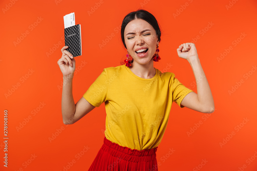 Image of emotional hispanic woman 20s dressed in skirt smiling while holding passport and travel tickets Image of emotional hispanic woman 20s dressed in skirt smiling while holding passport and travel tickets