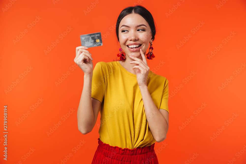 Image of brunette hispanic woman 20s dressed in skirt smiling and holding credit card Image of brunette hispanic woman 20s dressed in skirt smiling and holding credit card