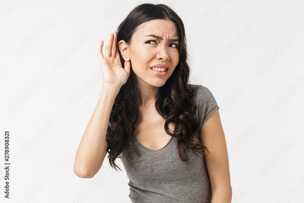 Concentrated young woman posing isolated over white wall background try to hear something. Concentrated young woman posing isolated over white wall background try to hear something.