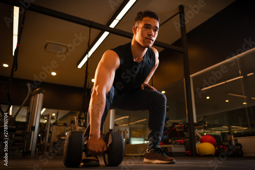 Athletic man playing dumbbell exercise for arm endurance training exercise to strengthen and tone the shoulder muscles. concept of weight training.