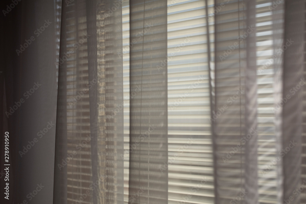 Gray transparen curtains at wide jalousie window. Gray transparen curtains at wide jalousie window.