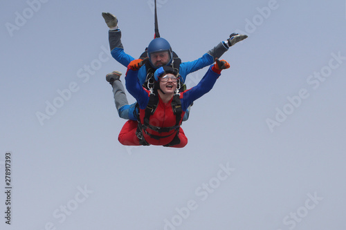Tandem skydiving. Man and woman are in the sky.