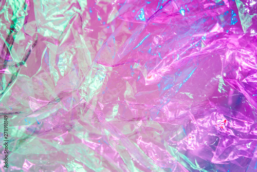 Holographic background in the style of the 80-90s. Real texture of cellophane film in bright acid colors. photo