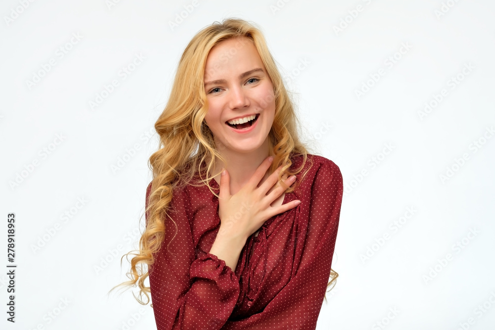 Pleased caucasian curly woman wearing red shirt laughing broadly glad to receive compliments from friends. Positive facial human emotion Pleased caucasian curly woman wearing red shirt laughing broadly glad to receive compliments from friends. Positive facial human emotion