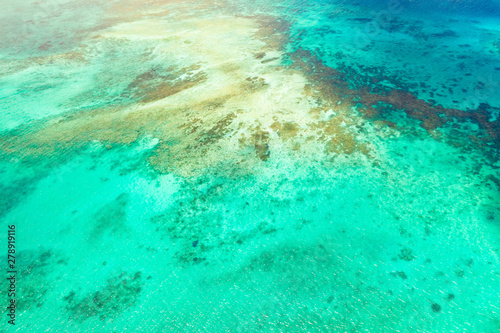 Bright lagoon with clear water and corals, top view. Sea surface above the sea atoll. Seascape. © Tatiana Nurieva