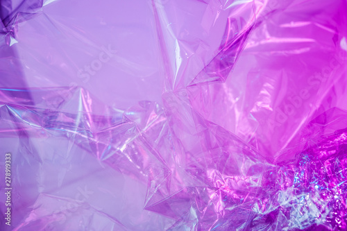 Holographic background in the style of the 80-90s. Real texture of cellophane film in bright acid colors.
