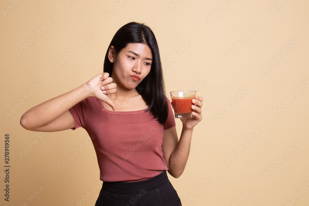 Asian woman thumbs down hate tomato juice. Asian woman thumbs down hate tomato juice.